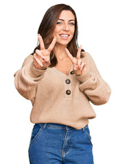 Poster - Young brunette woman wearing casual winter sweater smiling looking to the camera showing fingers doing victory sign. number two.