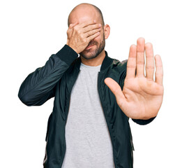 Sticker - Young hispanic man wearing casual clothes covering eyes with hands and doing stop gesture with sad and fear expression. embarrassed and negative concept.