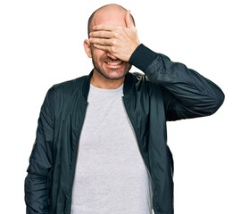 Sticker - Young hispanic man wearing casual clothes smiling and laughing with hand on face covering eyes for surprise. blind concept.