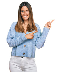 Wall Mural - Young woman wearing casual clothes smiling and looking at the camera pointing with two hands and fingers to the side.