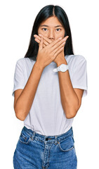 Wall Mural - Beautiful young asian woman wearing casual white t shirt shocked covering mouth with hands for mistake. secret concept.