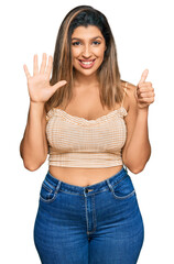 Poster - Beautiful brunette woman wearing casual clothes showing and pointing up with fingers number six while smiling confident and happy.