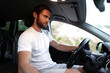 © fotofabrika - Bearded young man in casual t-shirt drives a car
