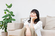 © Paylessimages - リビングでリラックスする女性