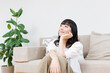 © Paylessimages - リビングでリラックスする女性