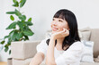 © Paylessimages - リビングでリラックスする女性