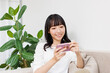 © Paylessimages - スマホで動画を見ている女性