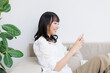 © Paylessimages - スマホで動画を見ている女性