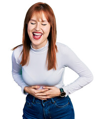 Wall Mural - Redhead young woman wearing casual turtleneck sweater smiling and laughing hard out loud because funny crazy joke with hands on body.