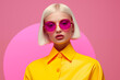 blond model wearing yellow, editorial fashion shoot on pink studio background with circle