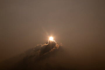 Wall Mural - The sun shines through the clouds in the sky. The sun shines through the clouds.