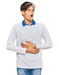 Canvas Print - Young hispanic man wearing casual clothes with hand on stomach because nausea, painful disease feeling unwell. ache concept.