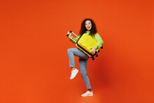 Full Body Traveler Woman In Casual Clothes Hold Suitcase Bag Pov Play Guitar Isolated On Plain Orange Background Tourist Travel Abroad In Free Spare Time Rest Getaway Air Flight Trip Journey Concept