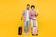 Traveler couple two friends family man woman wears casual clothes hold passport ticket bag isolated on plain yellow background. Tourist travel abroad in free time rest getaway Air flight trip concept