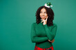 Merry fun little kid teen girl wear turtleneck hat casual clothes posing put hand prop up on chin, lost in thought isolated on plain green background studio Happy New Year celebration holiday concept