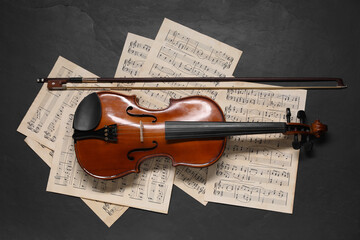 Sticker - Violin, bow and music sheets on black table, top view