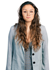 Sticker - Young hispanic girl wearing business clothes and glasses puffing cheeks with funny face. mouth inflated with air, crazy expression.