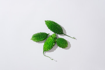 Sticker - On a white background, bitter melon also known as bitter gourd isolated. Top view, minimal scene of natural ingredient for skin care and hair care. Bitter melon is high in vitamins A and C