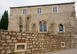 Fototapeta Miasto - An historic stone building on the waterfront of Bol town on Brac Island, Croatia