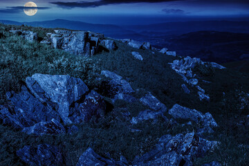 Wall Mural - sharp stones on the hillside in mountain landscape at night. mysterious nature scenery in full moon 