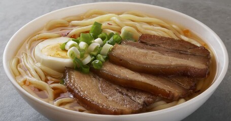 Canvas Print - Asian ramen noodles soup with egg, pork and onion. Close-up footage on the rotating table. 