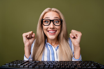 Poster - Photo portrait of blonde pretty young girl keyboard raise fists excited dressed stylish striped outfit isolated on khaki color background