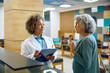 Senior patient talks to her doctor at medical clinic.