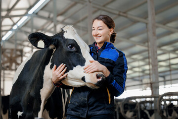 Wall Mural - Happy young woman farm worker hugging cow as sign of concern for animal health care. Concept agriculture cattle livestock farming industry