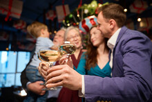 Family Hold Glasses Of Champagne Congratulating Each Other With New Year While