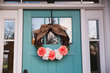 A spring floral wreath on a light blue aqua front door of a house home
