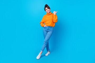 Sticker - Full length photo of cheerful funky lady wear knitted pullover walking showing thumb empty space isolated blue color background