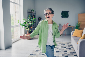 Wall Mural - Photo of attractive overjoyed resting funny pensioner business woman dancing moving arms enjoying weekends after job indoors at home