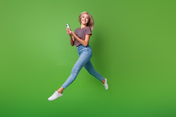 Poster - Full body length shot of funky lady browsing smartphone happy to see message from boyfriend running isolated on green color background