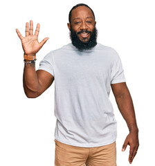 Poster - Young african american man wearing casual white tshirt showing and pointing up with fingers number five while smiling confident and happy.