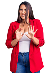 Poster - Young beautiful brunette woman wearing elegant clothes disgusted expression, displeased and fearful doing disgust face because aversion reaction. with hands raised