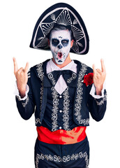 Poster - Young man wearing day of the dead costume over background shouting with crazy expression doing rock symbol with hands up. music star. heavy concept.