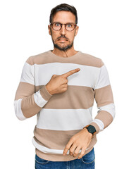 Sticker - Handsome man with beard wearing casual clothes and glasses pointing aside worried and nervous with forefinger, concerned and surprised expression