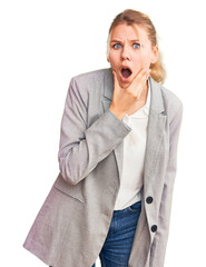 Wall Mural - Young beautiful blonde woman wearing elegant jacket looking fascinated with disbelief, surprise and amazed expression with hands on chin