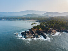 Aerial View Of Palolem Beach, A Tropical Beach With Coconut Trees And Cliffs In South Goa, India.