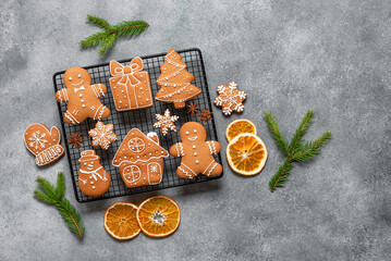 Wall Mural - Various Christmas gingerbread cookies decorated with fir branches and orange slices, gray concrete background. Top view, flat lay, space for text.