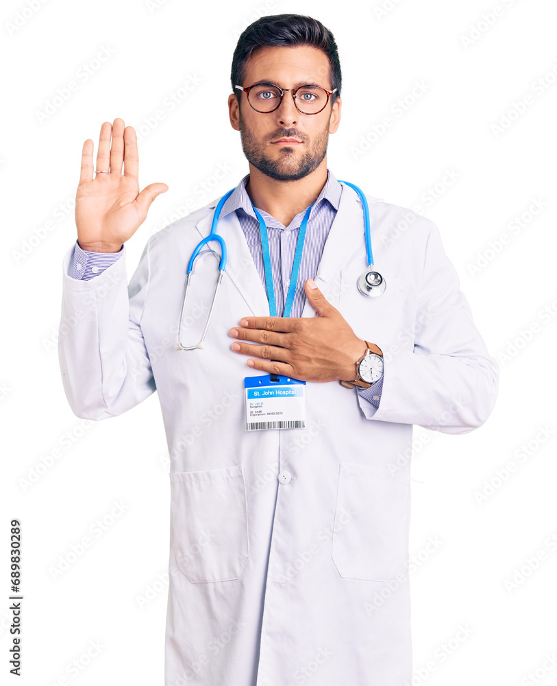 Young hispanic man wearing doctor uniform and stethoscope swearing with ...