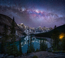View Of Lake Moraine At Night With The Milky Way Galaxy Visible In The Sky, A Beautiful Lake With Mountains And Snow In Banff National Park, Alberta, Canada.