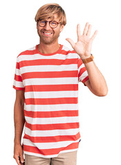 Poster - Handsome caucasian man with beard wearing casual clothes and glasses showing and pointing up with fingers number five while smiling confident and happy.