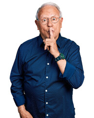 Sticker - Senior man with grey hair wearing casual shirt and glasses asking to be quiet with finger on lips. silence and secret concept.