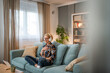 © Migma_Agency - A mature woman listens to a guided meditation on headphones, she is on the couch in her apartment and relaxes