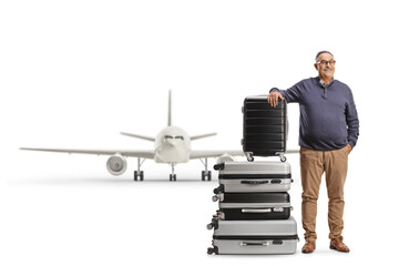 Canvas Print - Mature man leaning on a pile of suitcases in front of a jet