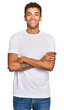 © Krakenimages.com - Young handsome african american man wearing casual white tshirt happy face smiling with crossed arms looking at the camera. positive person.