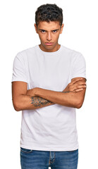 Sticker - Young handsome african american man wearing casual white tshirt skeptic and nervous, disapproving expression on face with crossed arms. negative person.