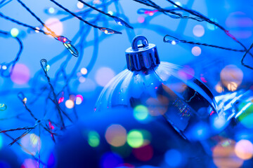 Wall Mural - christmas and new year blue color baubles decoration background with colourful lights of garlands. a