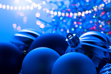 Wall Mural - christmas and new year blue color baubles decoration background with colourful lights of garlands. a